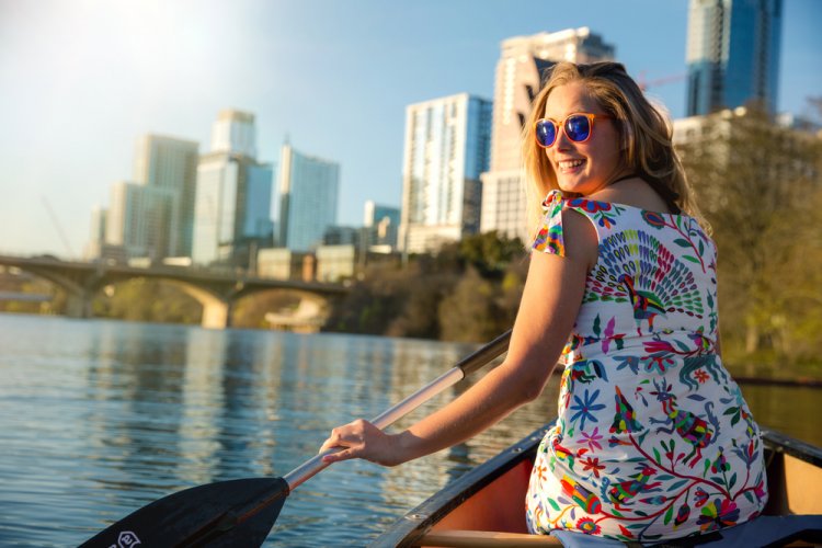 woman in a canoe rowing on Colorado river lake, happy, joyful in Austin Texas