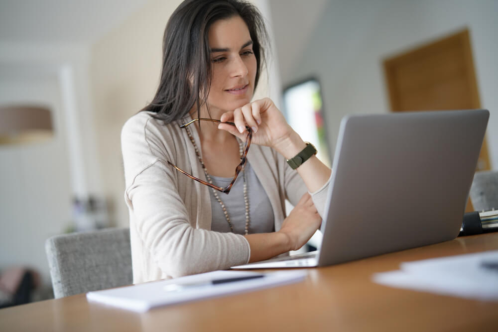 woman looking at laptop for collision car insurance