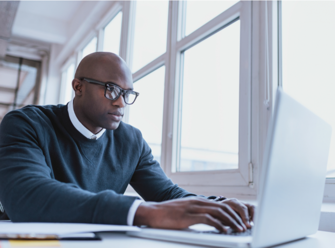 african american man on laptop searching for cheap auto insurance online