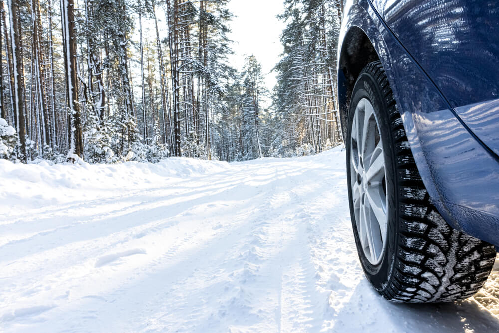 car's tires on winter road with snow