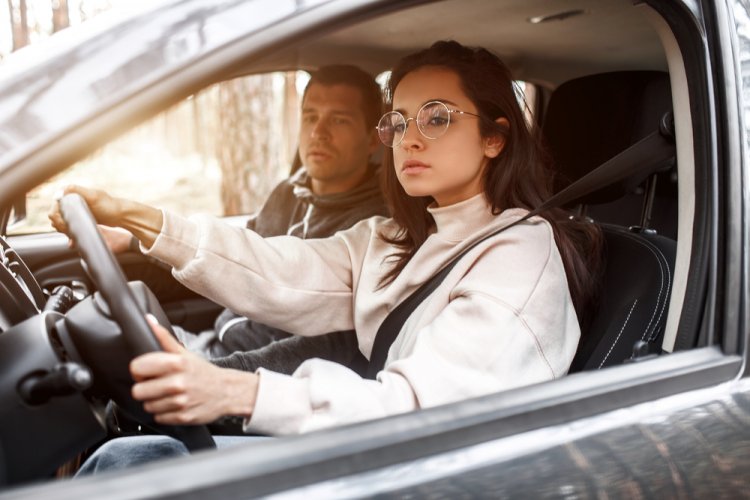 parent instructing teenage daughter how to drive