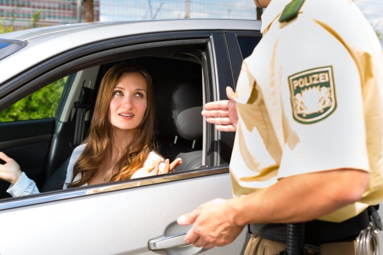 woman getting pulled over by police officer without proof of auto insurance