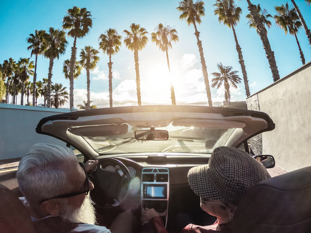 Senior couple driving a convertible in Florida