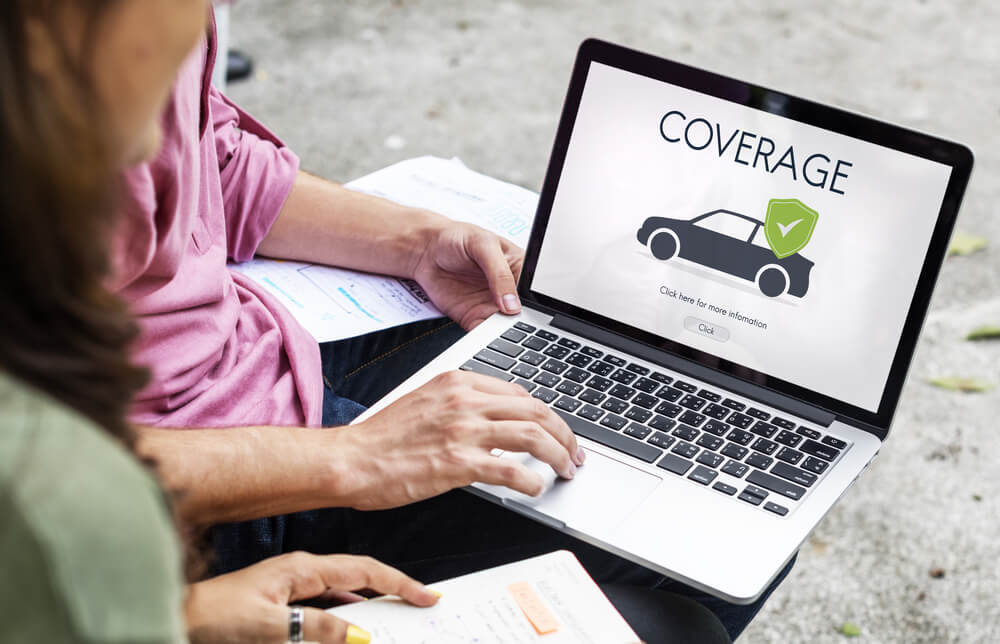 Looking at car insurance coverage on laptop