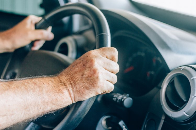 person with both hands on steering wheel