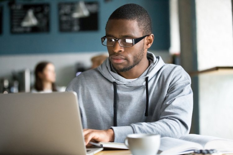 african american man searching for home insurance on laptop