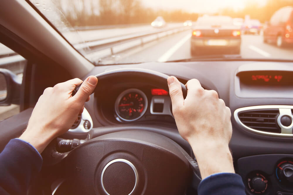 person driving safely with both hands on the steering wheel