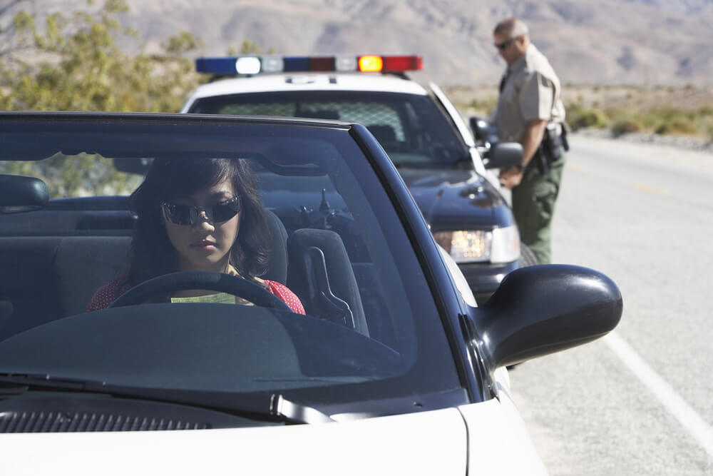 Young lady in sports car being pulled over by a police man