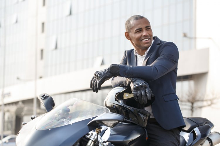 african american man sitting on motorcycle smiling