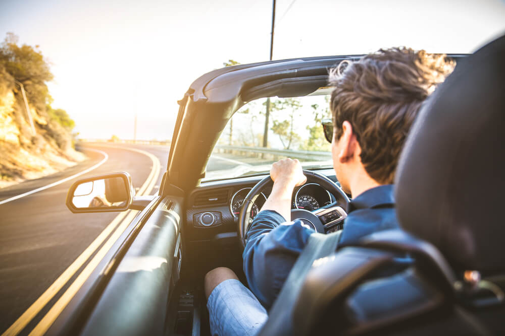 man driving car down highway which could be part of dangerous roads