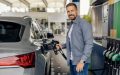 Man fueling his car at a gas station while looking for ways to save gas mileage.