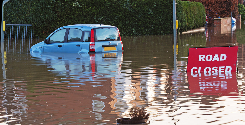 blue car is submerged in flood water