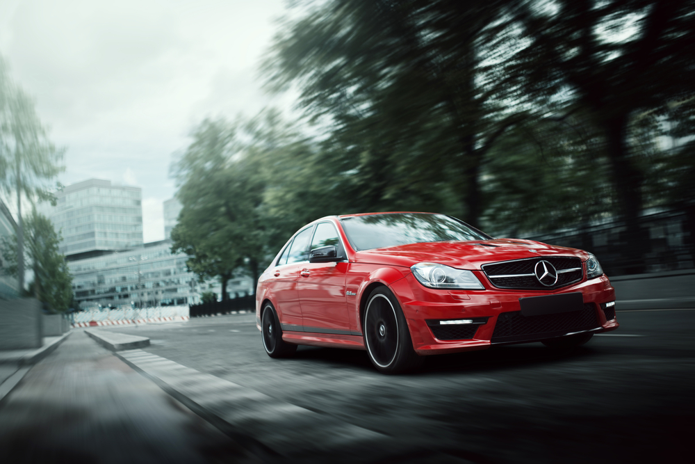 red car driving down road