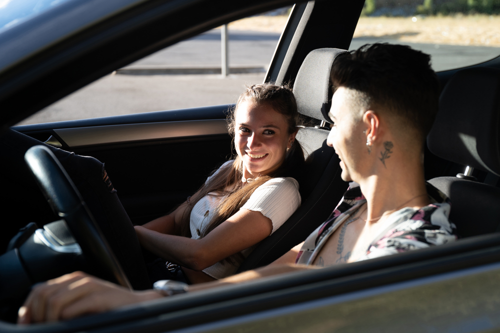 Young couple smiling in new car
