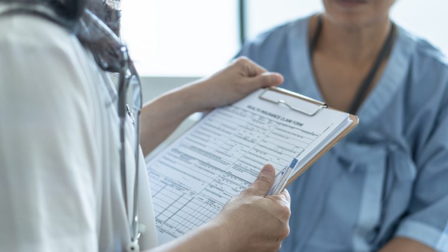 patient with doctor going over information on clipboard