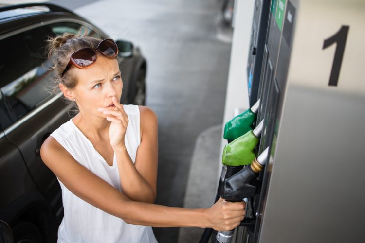Lady getting gas, worried about prices.