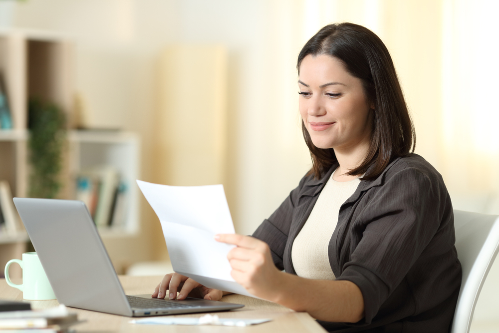 woman looking over health insurance open enrollment options at desk