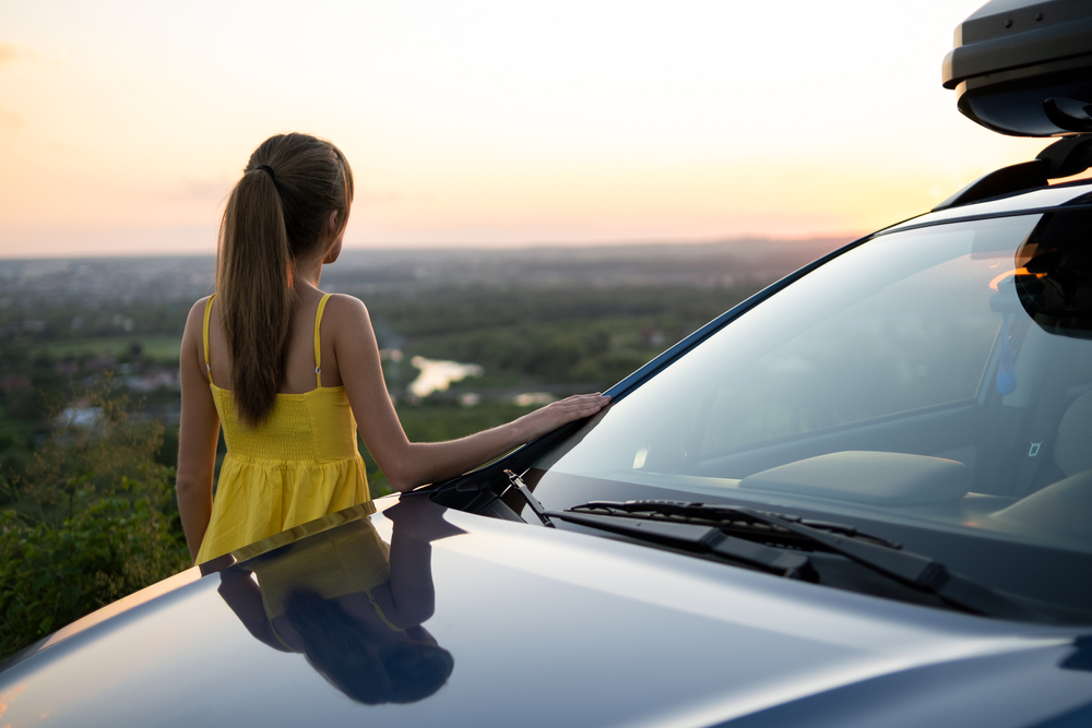 Young female driver contemplates factors that affect car insurance rates