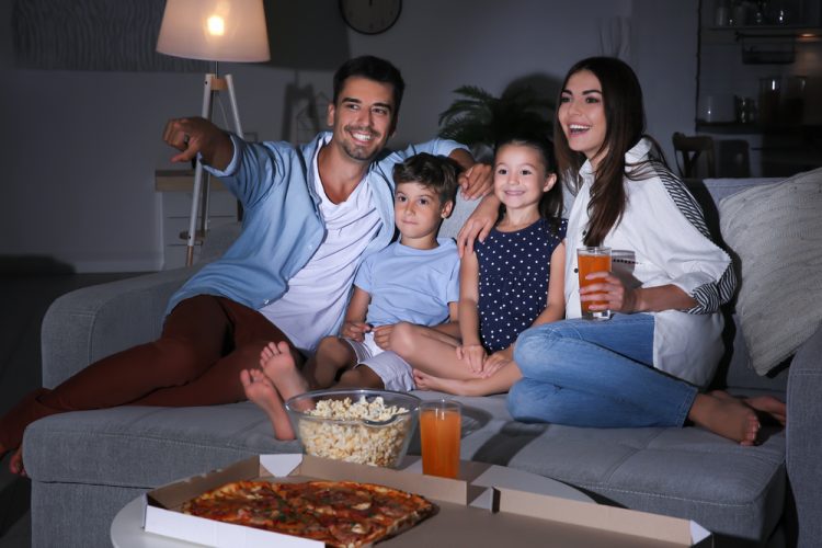 young hispanic family on the couch watching a movie