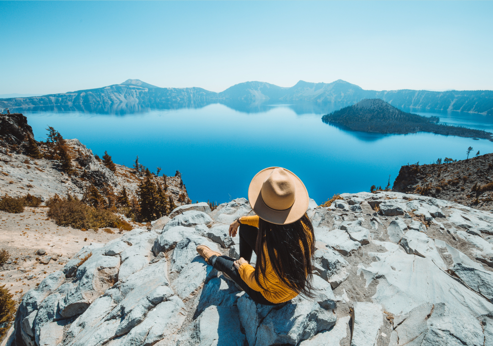 A woman sits on the Crater Lake overlook