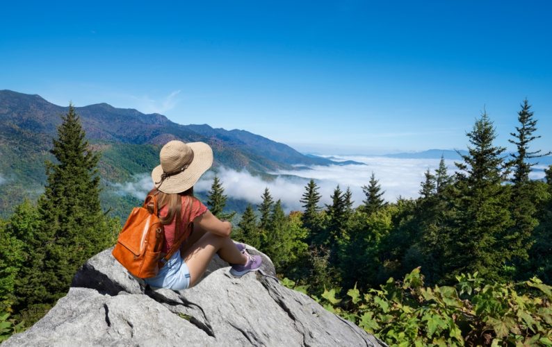 Woman relaxing on top of the mountain, over the clouds. Blue Ridge Parkway ,near Asheville, North Carolina, USA.