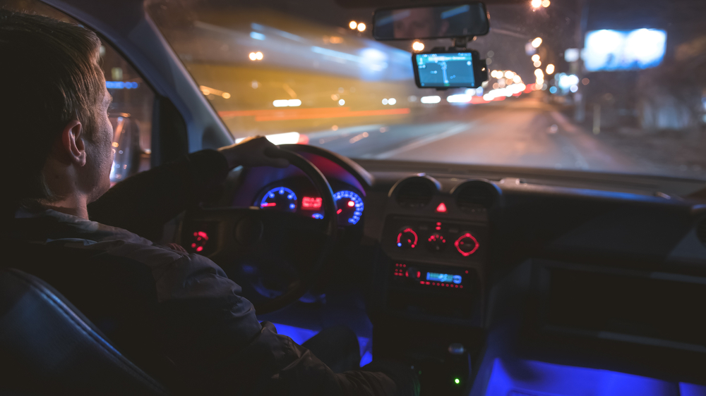 Man driving at night with dashboard lights
