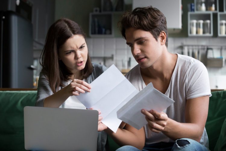 Young Hispanic couple stresses over car insurance increasing - cheap car insurance