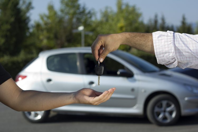 Hands handing over the car keys to another set of hands