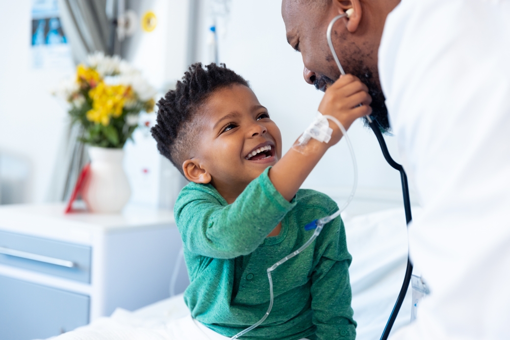 African American child plays with stethoscope around doctor's neck