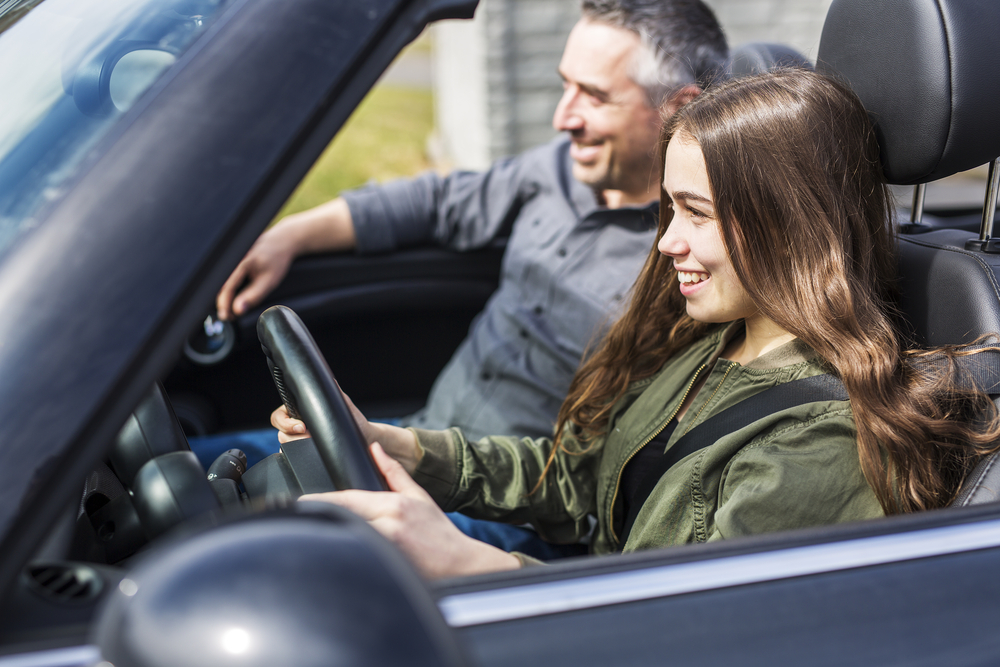 Young female driver learns to drive with father in car