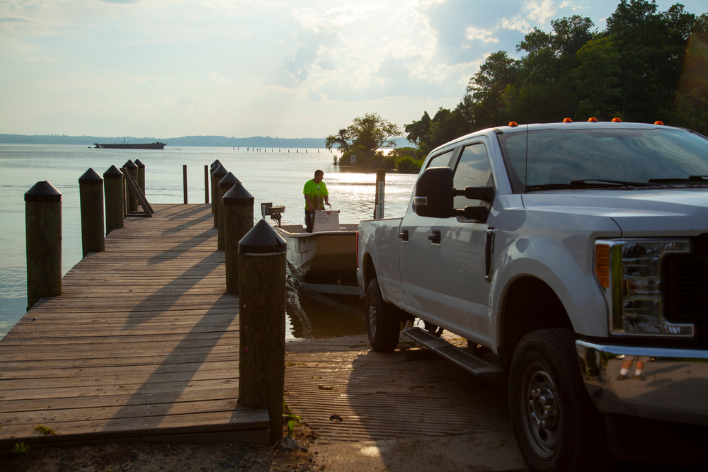 A man loads his boat onto his trailer from the water