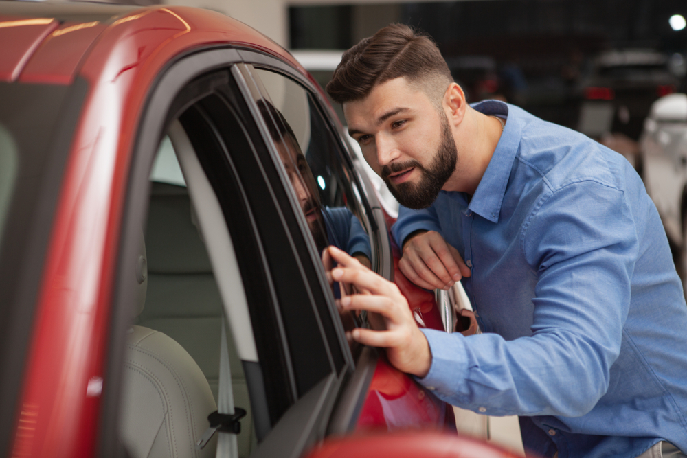 Young man examines a possible car to buy