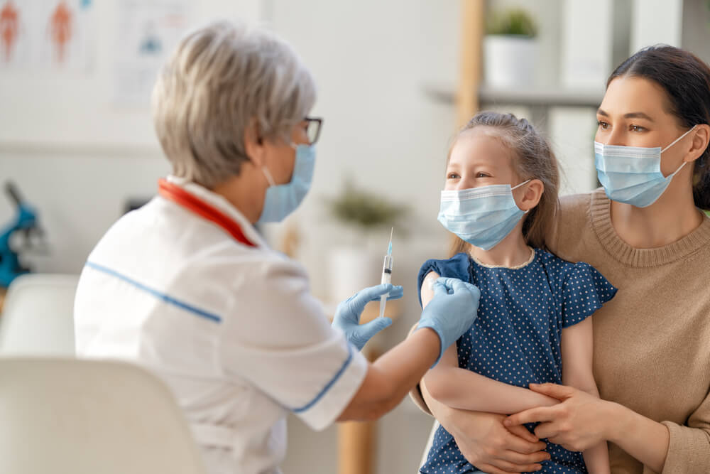 Child receiving a vaccine from a healthcare provider with parent present, highlighting the importance of vaccines for family health