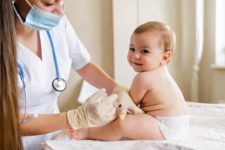 A medical professional administering a vaccine to an infant - cheap health insurance