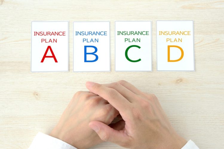 Wooden blocks from A to D, concept of comparing 4 different insurance plans when switching.