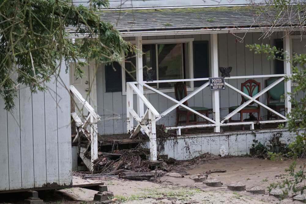 A ruined house that was flooded is posted no trespassing - cheap home insurance.