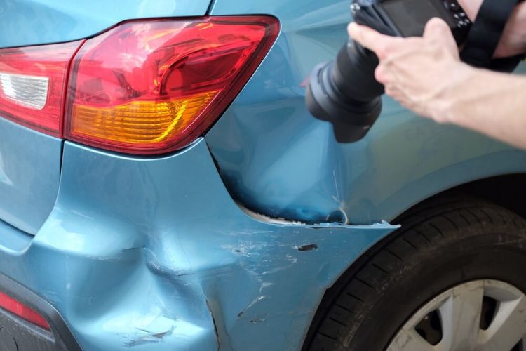 Woman takes picture of her bumper after being hit by an uninsured driver - cheap uninsured motorist coverage.