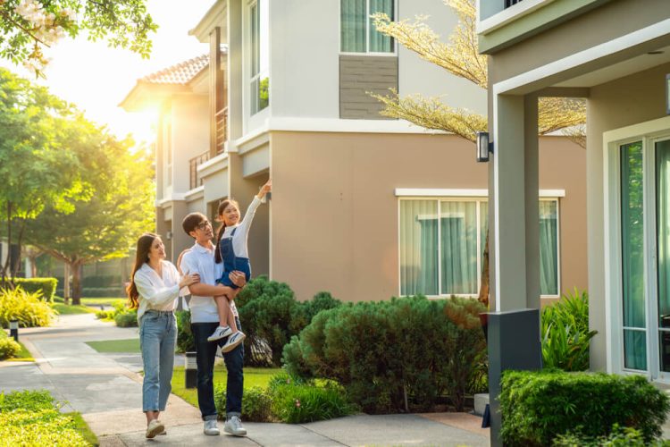 A young couple with a baby strolls through their apartment complex - cheap renters insurance.