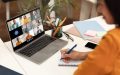 A female remote employee joins a call with her colleagues on her laptop from home - cheap home insurance.