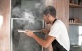 Man's oven is smoking, illustrating the need for a home warranty that protects appliances - cheap home insurance.