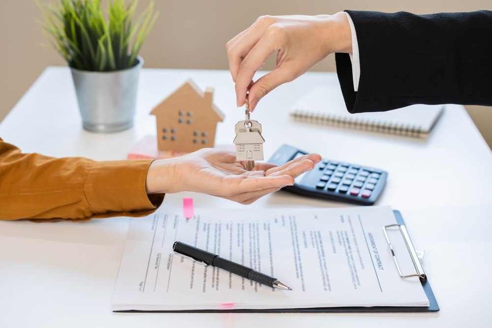 Tenant receiving house keys while reviewing if renters insurance is a money saver or unnecessary expense.