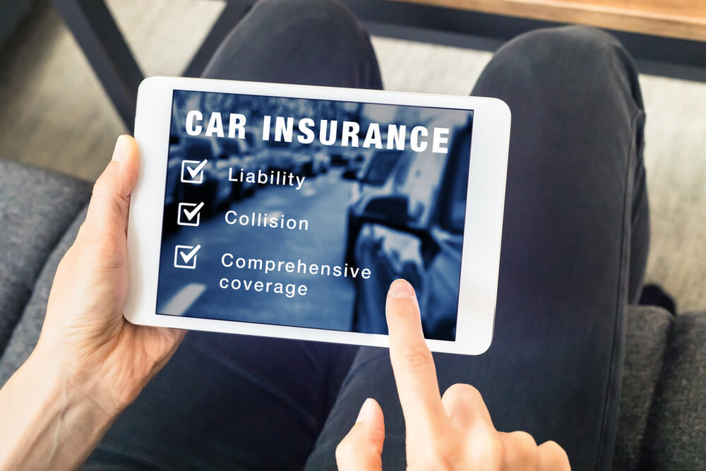 Person choosing car insurance coverage options (liability, collision, comprehensive) on website on digital tablet computer screen, vehicle and risk protection.