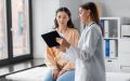 Medicine, healthcare and people concept - female doctor with tablet pc computer talking to woman patient at hospital, help finding cheap health insurance in California.