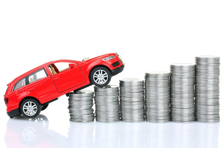 Coins and sports red car blur in background illustrate auto insurance rate increase 2025.