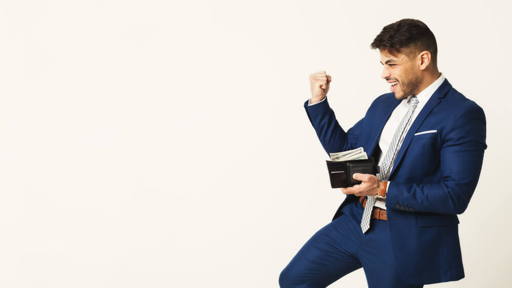 Happy businessman with full money wallet, saving money on business insurance. 