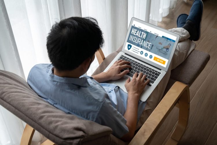 Back view of man looking at health insurance web site registration and the Covered California metal tiers.