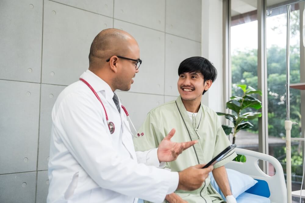 Medical professional giving advice to young man consulting about treatment and Covered California metal tiers.