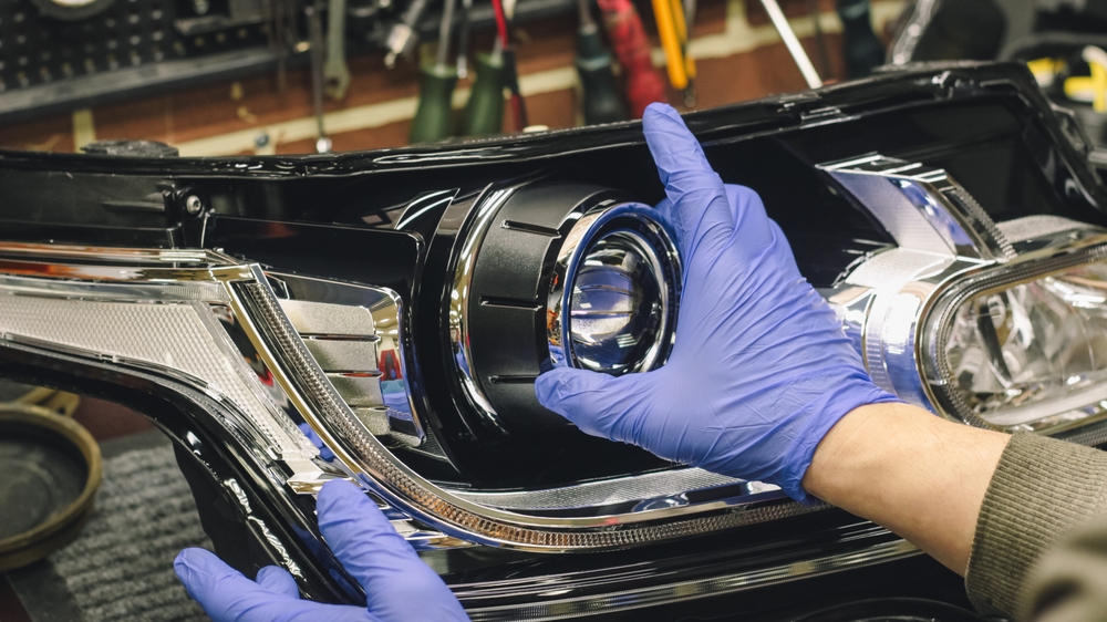 Repairman replaces a modern LED headlight close-up, supporting the topic are LED headlights better for drivers.