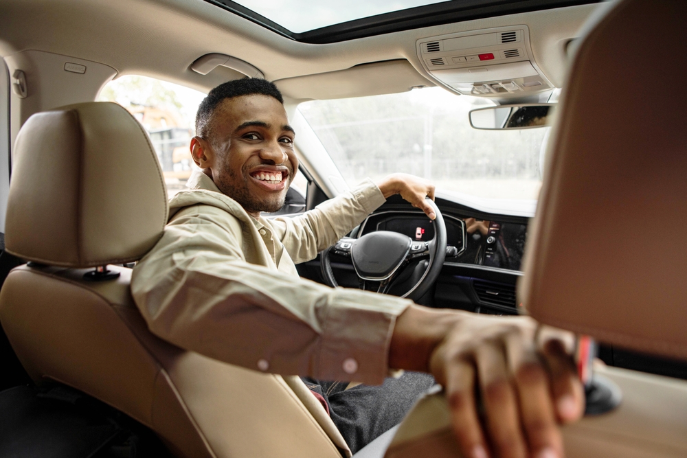 Joyful African American Man Smiling Sitting In Automobile Looking Back At Camera