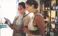Small business owners reviewing orders on a tablet, representing online business insurance for handmade and creative businesses.